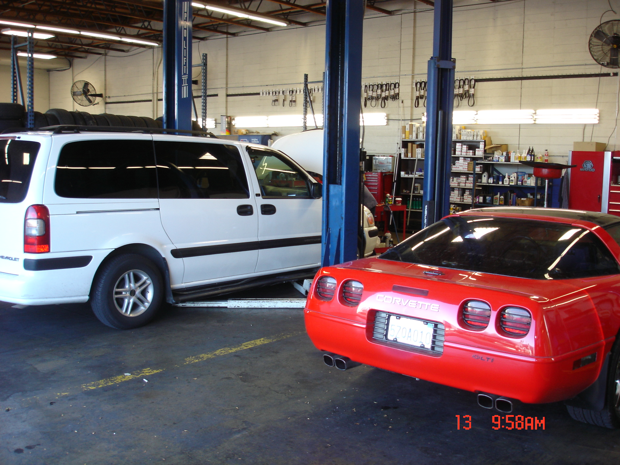 Original shop photo showing a van and red Corvette in the service area